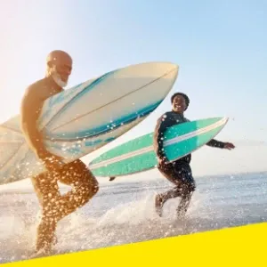 A group of people smiling after surfing together.