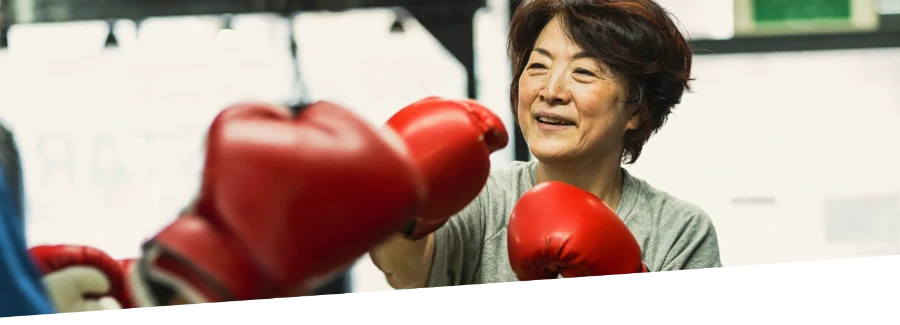A woman practicing boxing inside.