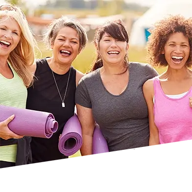 A group of women smile after doing yoga.