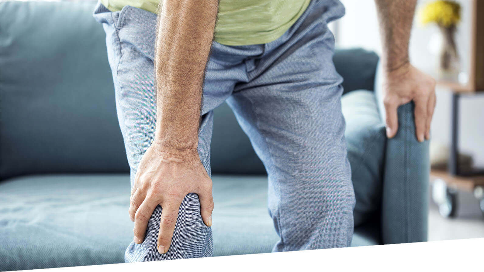 A man holds his knee and appears to be in pain.