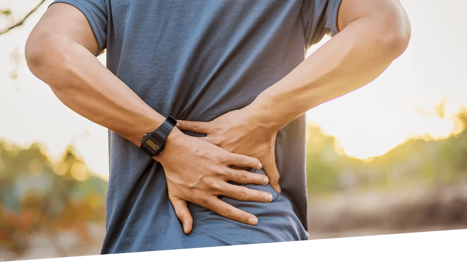 A man holds his lower back.